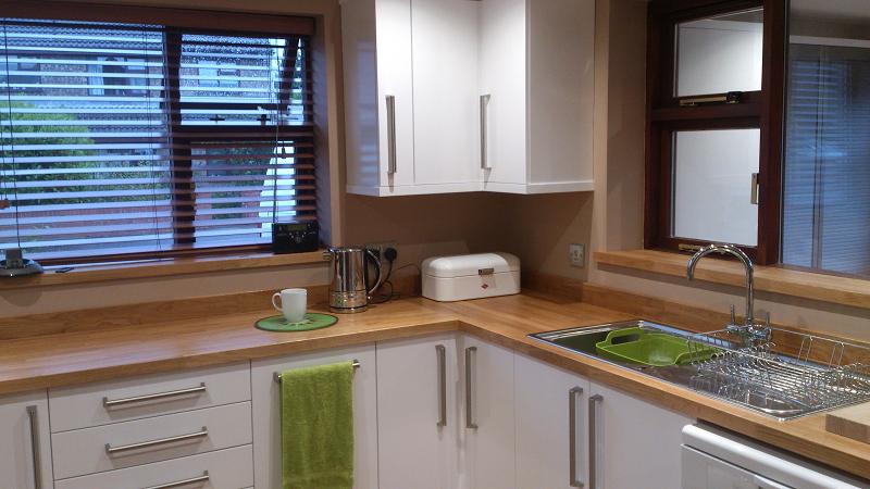 Logica White Gloss kitchen fitted with oak worktops